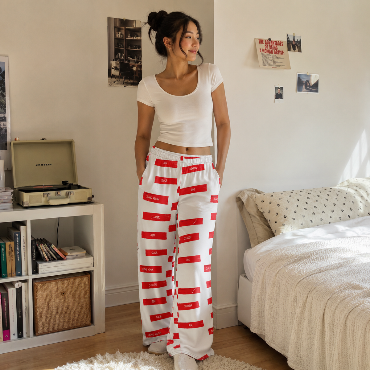Woman in a bedroom wearing white and red striped pants.