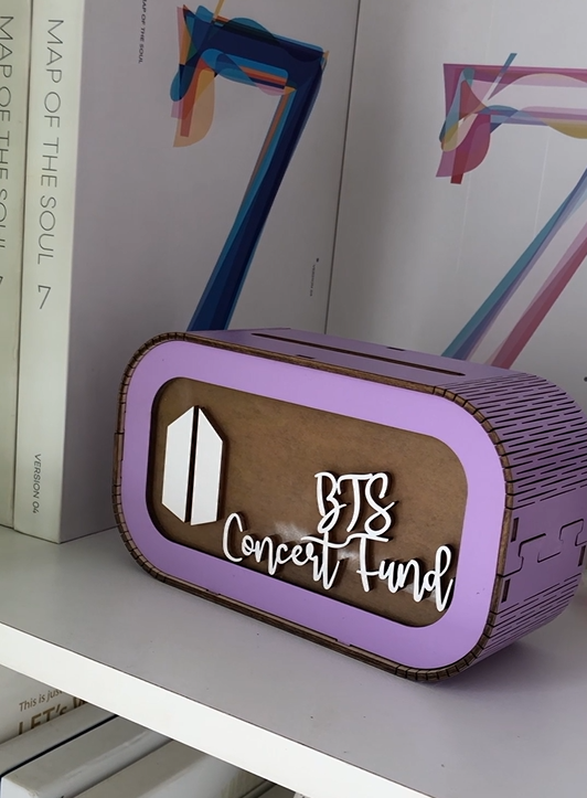 Photo on fan&#39;s shelf of purple BTS concert piggybank
