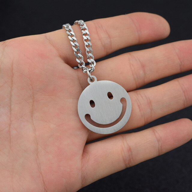 J-Hope 'Sunshine' smiley necklace held in a hand, emphasizing the playful smiley face design, perfect for fans.